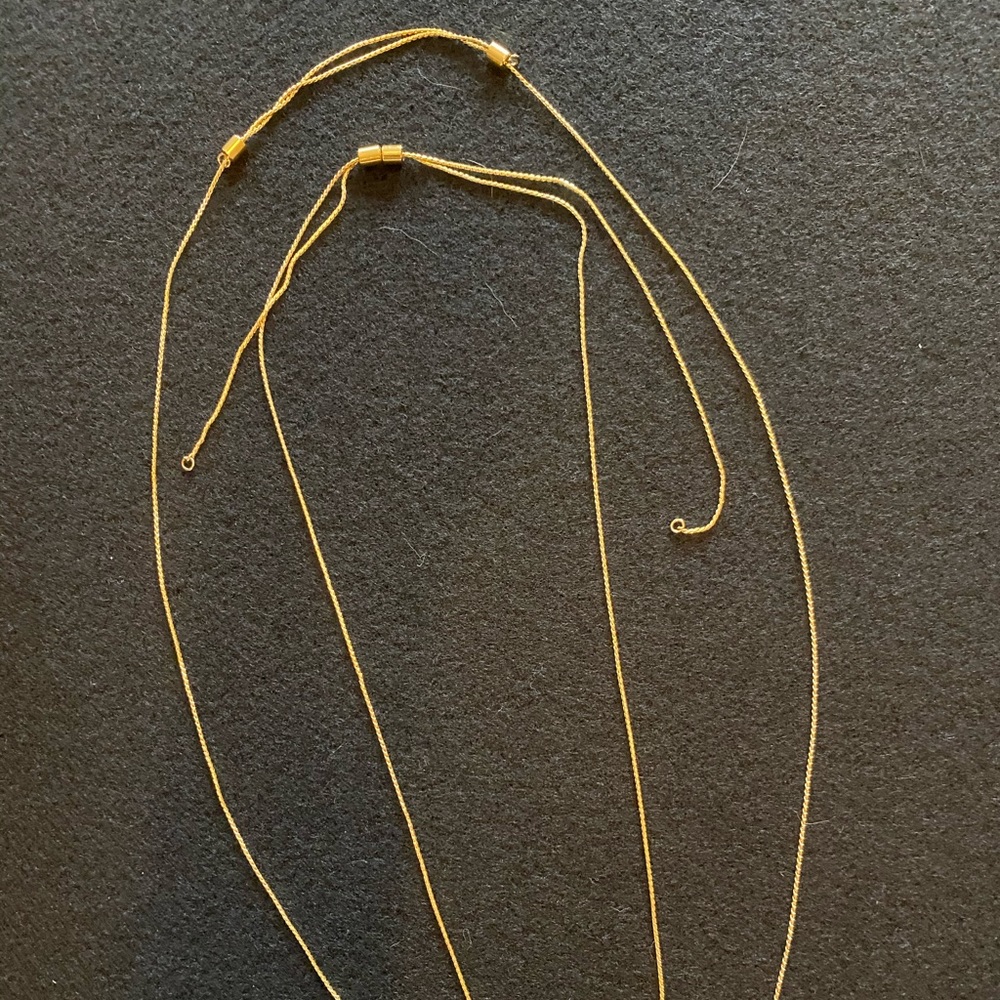 Set of two adjustable gold chains.